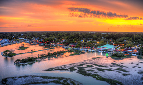 Aerial view of a vibrant sunset over a scenic riverside town.
